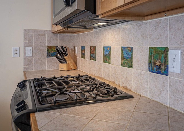 interior space featuring gas range and backsplash