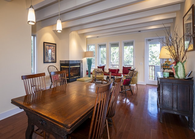 dining space with beamed ceiling, a premium fireplace, and dark hardwood / wood-style flooring