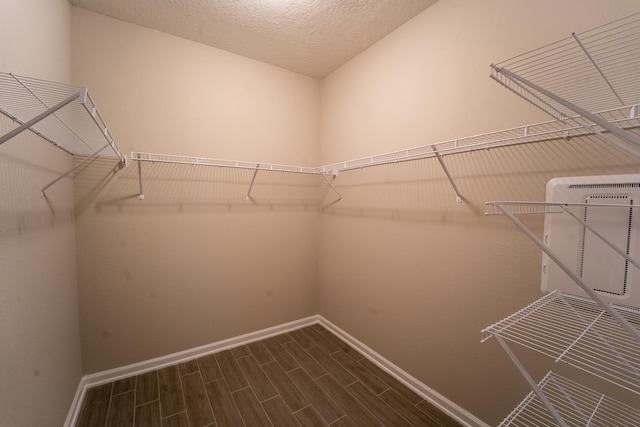 spacious closet featuring dark hardwood / wood-style flooring