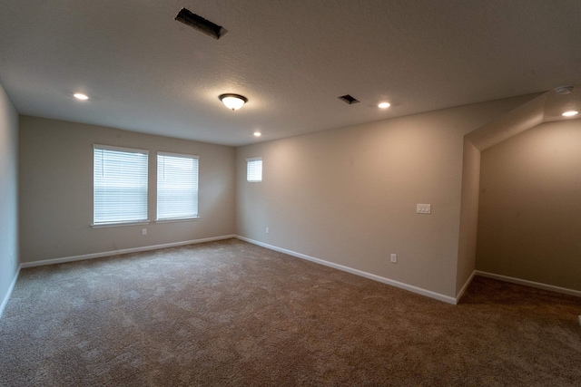 carpeted empty room with a textured ceiling