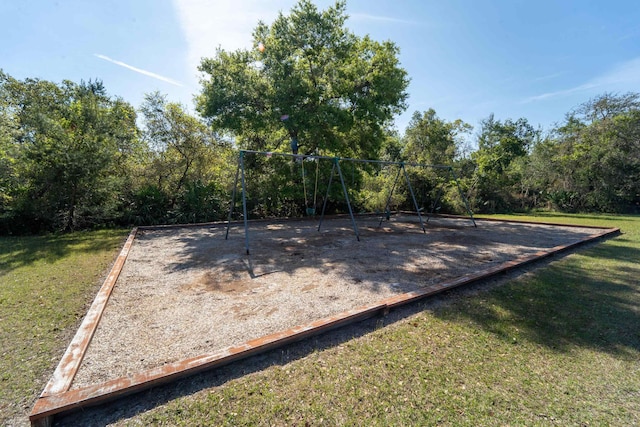 view of property's community featuring a playground and a lawn