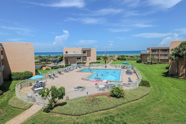 view of swimming pool with a water view, a lawn, and a patio