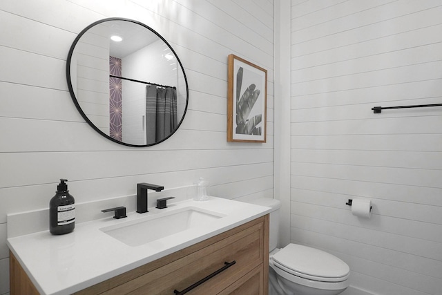 bathroom with vanity, toilet, curtained shower, and wooden walls