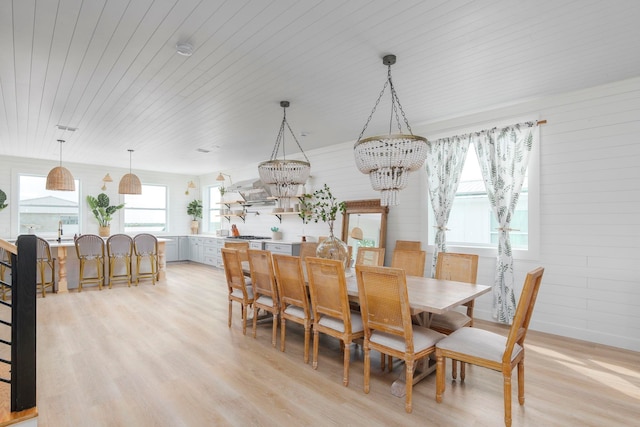 dining area with a chandelier, light hardwood / wood-style flooring, wooden ceiling, and sink