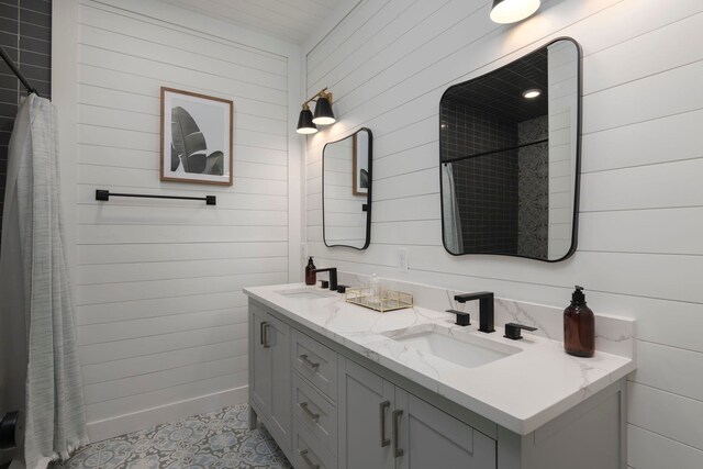 bathroom with wood walls, tile patterned flooring, and vanity