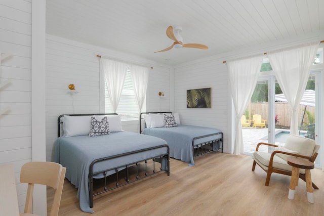 bedroom featuring access to outside, multiple windows, ceiling fan, and light hardwood / wood-style flooring