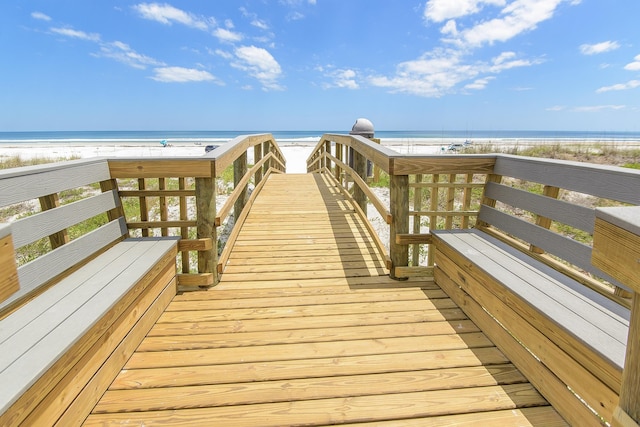 view of property's community with a water view and a beach view