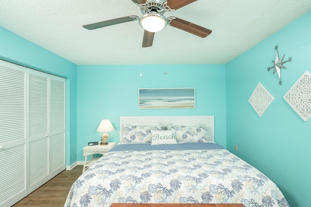 bedroom with hardwood / wood-style floors, ceiling fan, a textured ceiling, and a closet