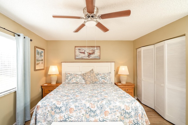 bedroom featuring ceiling fan, a closet, light hardwood / wood-style floors, and a textured ceiling