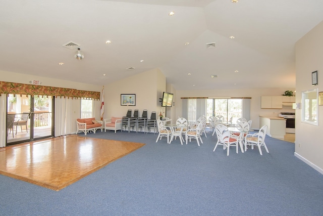 dining space featuring plenty of natural light, carpet floors, and vaulted ceiling