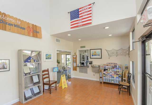 interior space with tile patterned flooring and a towering ceiling