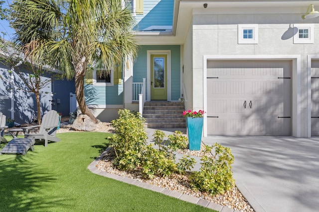 view of exterior entry featuring a garage and a lawn