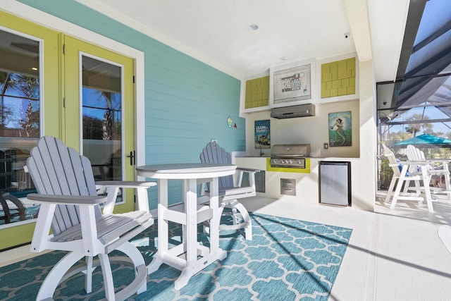 view of patio / terrace with grilling area, glass enclosure, an outdoor kitchen, and french doors