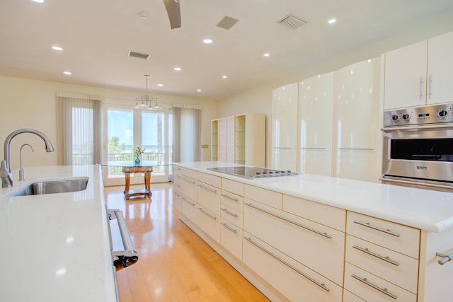 4 Oceanside Dr, Saint Augustine Beach, FL 32080 - kitchen with stainless steel oven, electric stovetop, recessed lighting, light wood-style floors, and white cabinetry