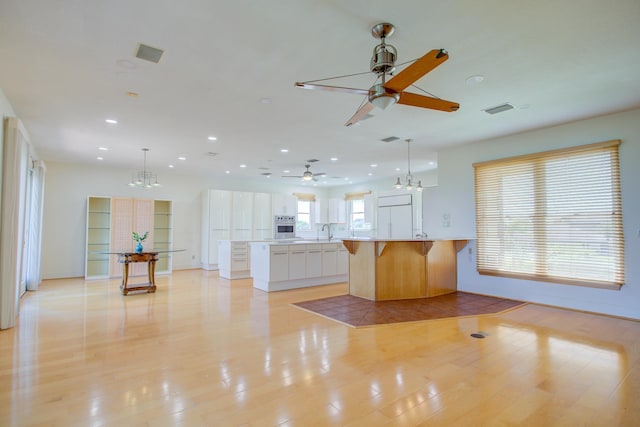 4 Oceanside Dr, Saint Augustine Beach, FL 32080 - kitchen featuring ceiling fan, a chandelier, oven, a kitchen bar, and recessed lighting