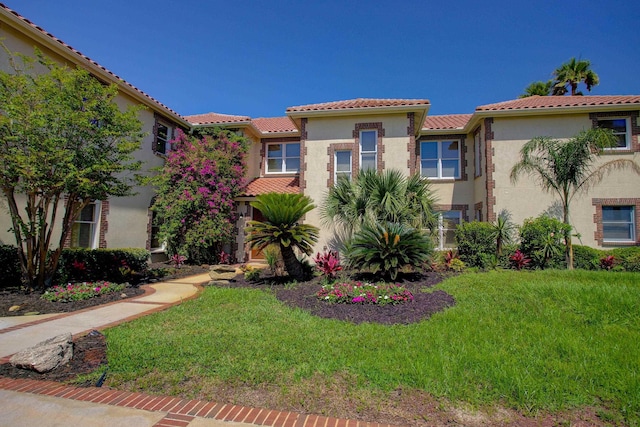 4 Oceanside Dr, Saint Augustine Beach, FL 32080 - mediterranean / spanish home with stucco siding, a front lawn, and a tile roof