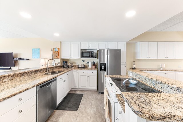 7780 S A1A Unit 101, Saint Augustine, FL 32080 - kitchen with appliances with stainless steel finishes, white cabinets, light stone counters, and recessed lighting