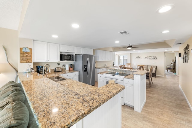 7780 S A1A Unit 101, Saint Augustine, FL 32080 - kitchen featuring stainless steel appliances, a ceiling fan, white cabinetry, a peninsula, and recessed lighting