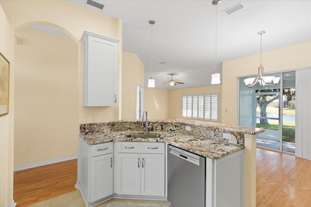 1021 Windward Way, Saint Augustine, FL 32080 - kitchen featuring dishwasher, light wood finished floors, white cabinets, light stone countertops, and a peninsula