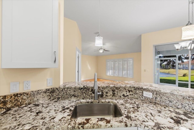 1021 Windward Way, Saint Augustine, FL 32080 - kitchen view of light stone countertops, white cabinetry, pendant lighting, a chandelier, and a ceiling fan