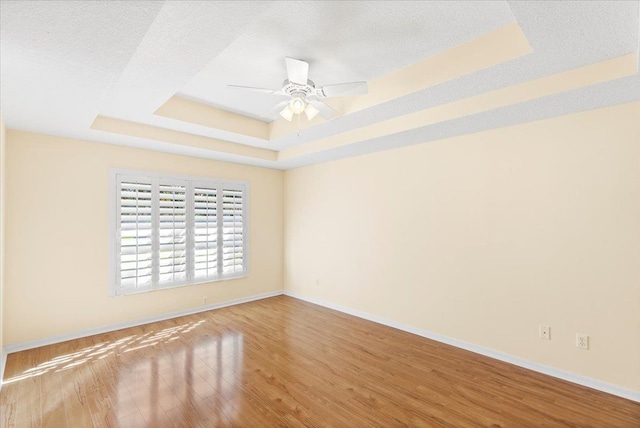 1021 Windward Way, Saint Augustine, FL 32080 - unfurnished room featuring a tray ceiling, wood finished floors, and ceiling fan