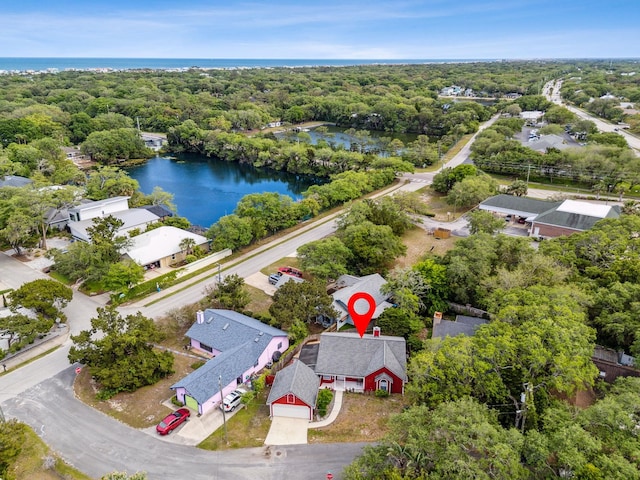 aerial view with a water view and a wooded view