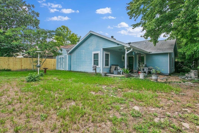 rear view of property with a yard and a patio