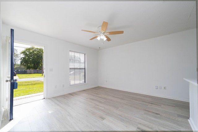 empty room with ceiling fan and light hardwood / wood-style flooring