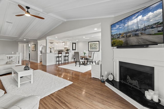 living room featuring vaulted ceiling with beams, ceiling fan, wood-type flooring, and wooden ceiling