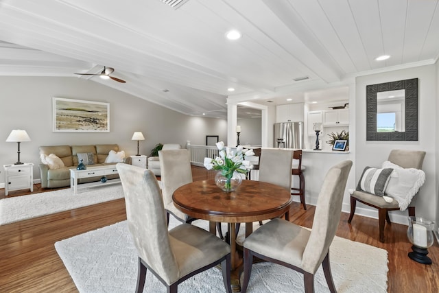 dining area with vaulted ceiling with beams, light hardwood / wood-style floors, crown molding, and ceiling fan