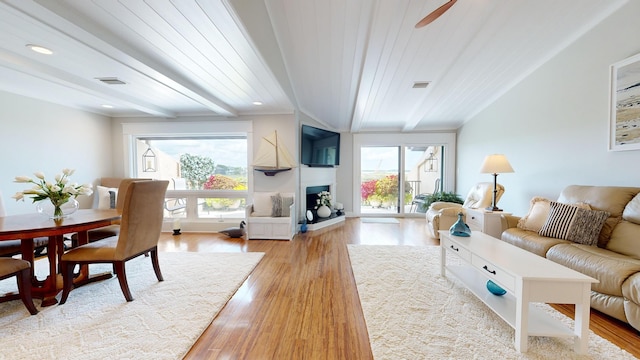 living room featuring wooden ceiling, light hardwood / wood-style floors, ceiling fan, and a healthy amount of sunlight