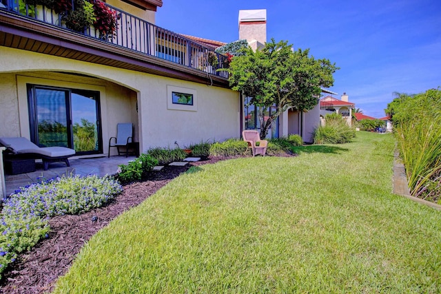 view of yard with a balcony and a patio