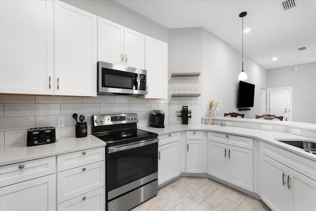 kitchen with appliances with stainless steel finishes, white cabinets, and light countertops