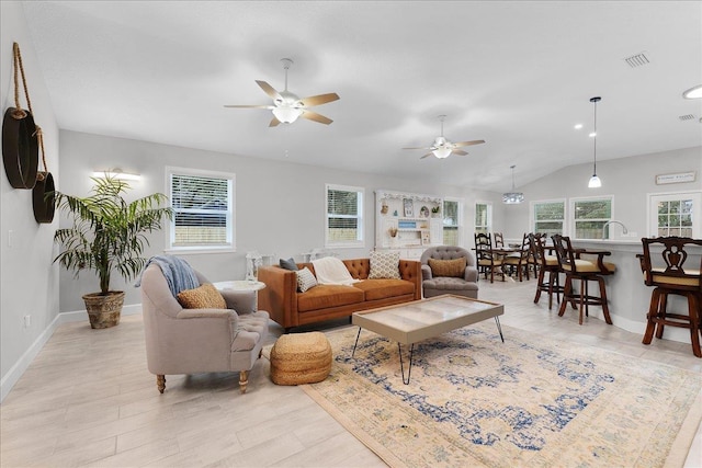 living room with baseboards, visible vents, vaulted ceiling, and a ceiling fan