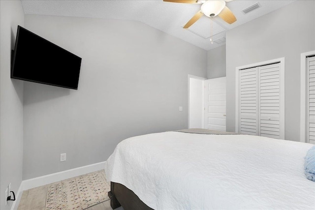 bedroom featuring baseboards, visible vents, vaulted ceiling, and a ceiling fan