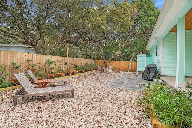 view of yard featuring a fire pit, a patio, and a fenced backyard