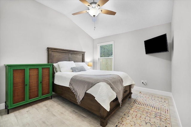 bedroom with ceiling fan, baseboards, and vaulted ceiling