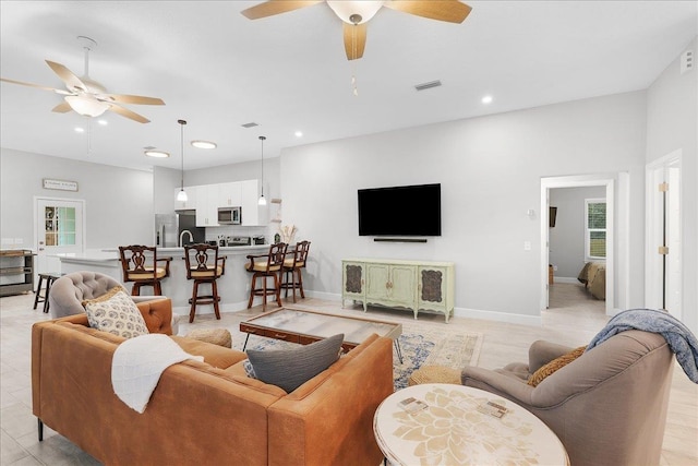 living room featuring baseboards, ceiling fan, visible vents, and recessed lighting