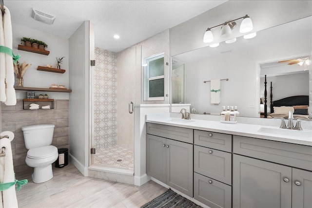 full bath featuring a shower stall, a sink, visible vents, and connected bathroom