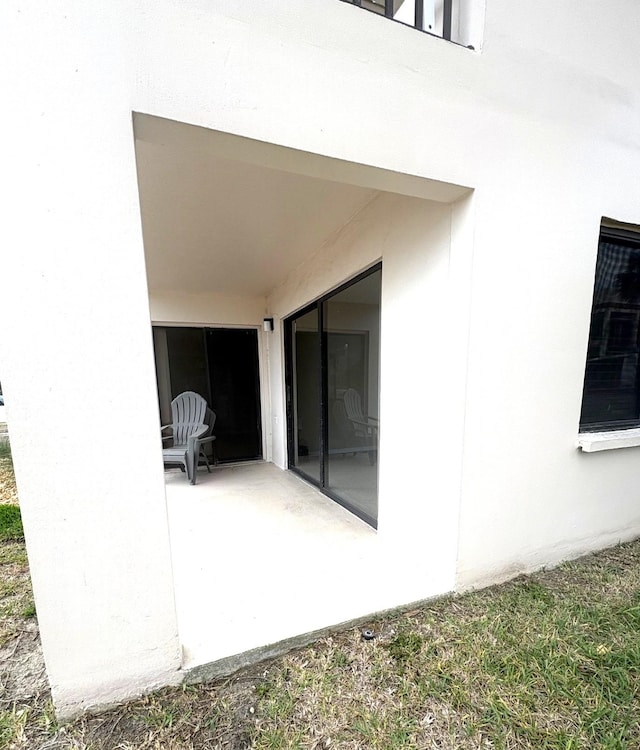 rear view of house with a patio and stucco siding