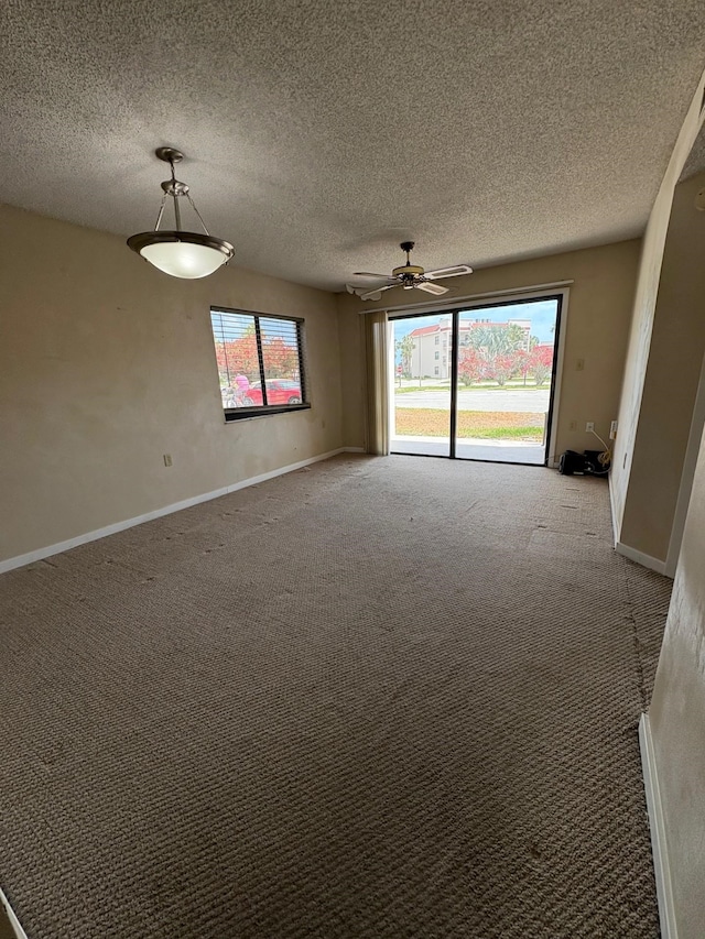 empty room featuring light carpet, a textured ceiling, and a ceiling fan