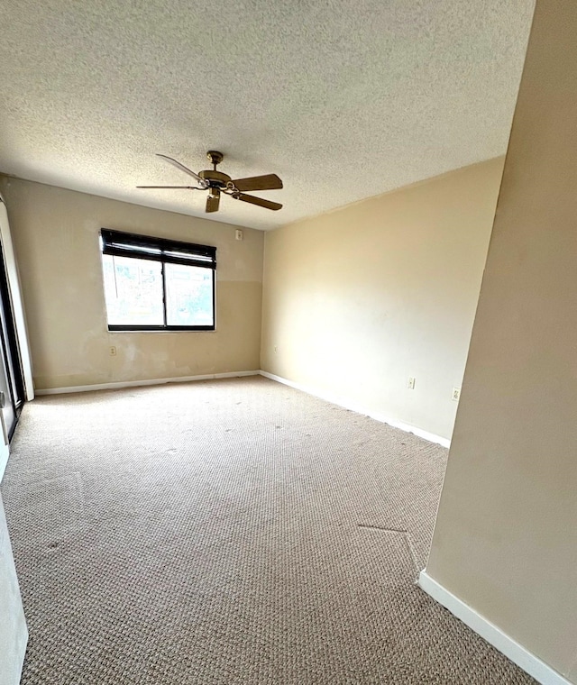 empty room featuring a ceiling fan, a textured ceiling, baseboards, and carpet