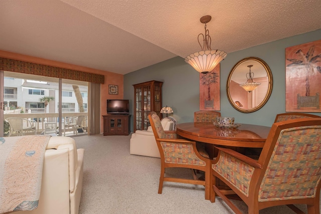 carpeted dining space with a textured ceiling