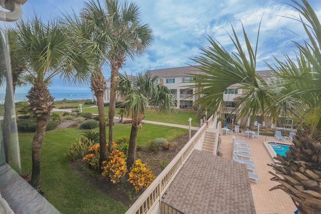 view of property's community featuring a lawn, a water view, a patio, and a pool