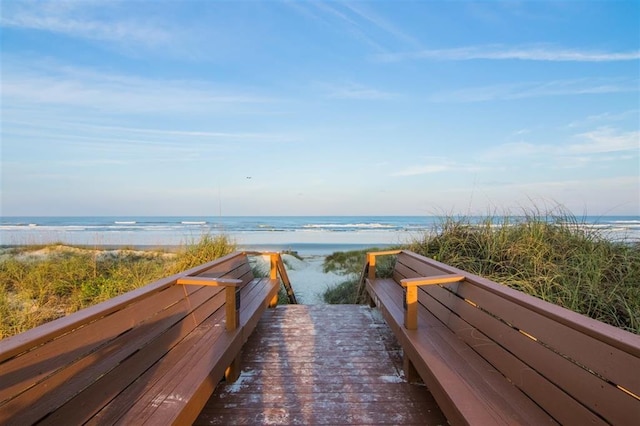 view of property's community with a water view and a view of the beach