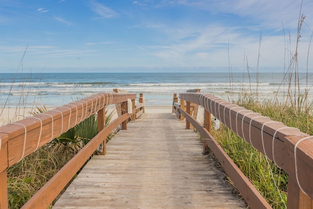 surrounding community with a beach view and a water view