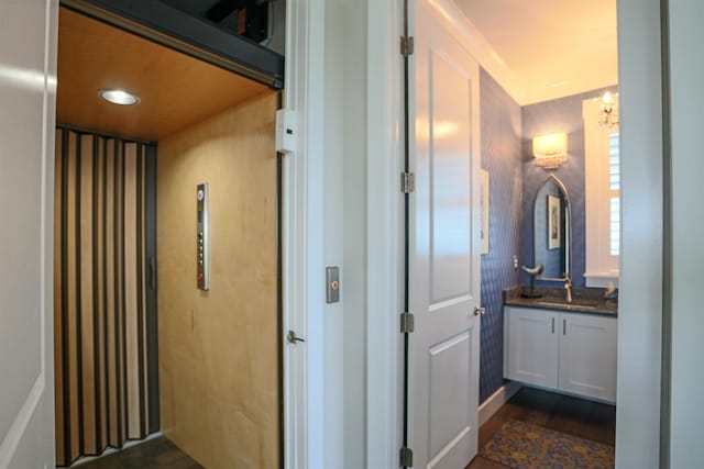 bathroom featuring elevator, vanity, wood-type flooring, and a notable chandelier