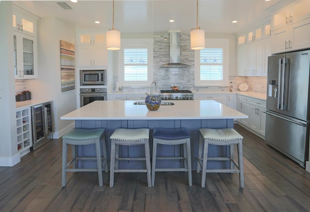 kitchen featuring white cabinetry, wall chimney exhaust hood, and appliances with stainless steel finishes
