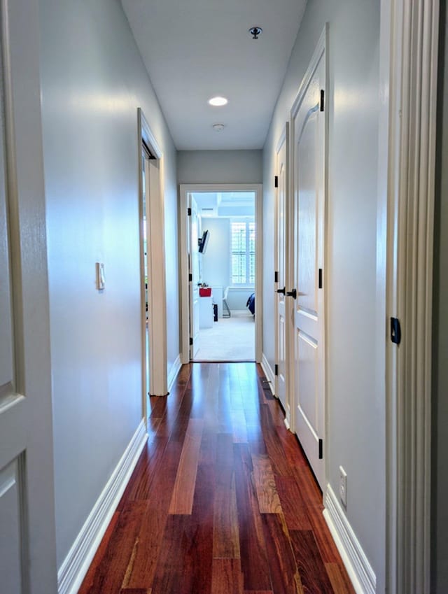 hallway with dark hardwood / wood-style flooring