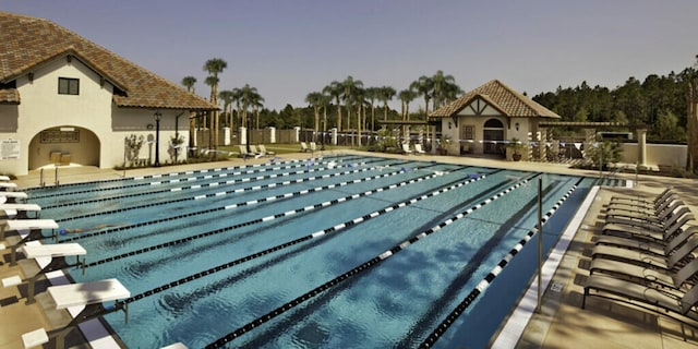 pool at dusk with a patio area